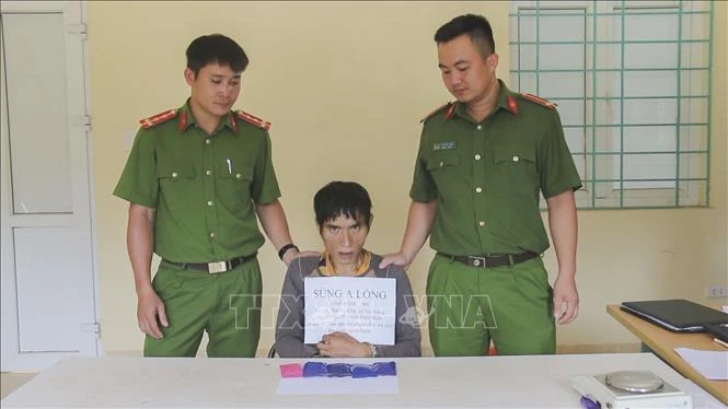 Đối tượng Sùng A Lồng cùng tang vật tại cơ quan điều tra. Ảnh: Xuân Tư – TTXVN
