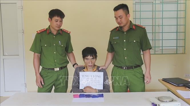 Đối tượng Sùng A Lồng cùng tang vật tại cơ quan điều tra. Ảnh: Xuân Tư – TTXVN