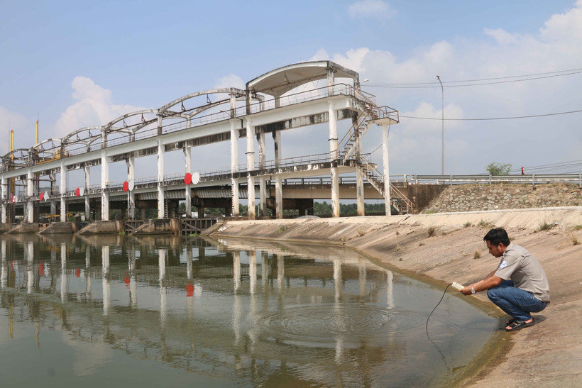 Anh Nguyễn Chế Linh, công nhân quản lý cống Láng Thé, xã Đại Phước, huyện Càng Long (Trà Vinh) đo độ mặn nước trong cống. Ảnh: Thanh Hòa-TTXVN 