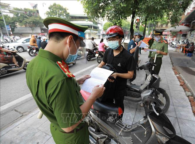 Lực lượng chức năng kiểm tra giấy tờ liên quan của người dân khi tham gia giao thông tại chốt phòng, chống dịch trên tuyến phố Lê Thanh Nghị, phường Bạch Mai, quận Hai Bà Trưng. Ảnh: Vũ Sinh – TTXVN 