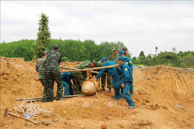 Lực lượng chức năng di dời quả bom. Ảnh: TTXVN phát