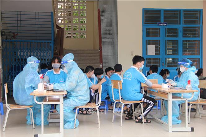 Học sinh được khám sàng lọc trước khi tiêm vaccine phòng COVID-19 tại điểm tiêm Trường THCS Lý Tự Trọng, thành phố Trà Vinh. Ảnh: Thanh Hòa - TTXVN 