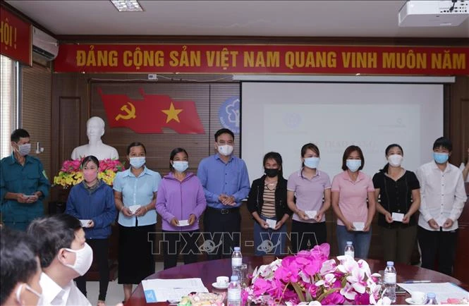 Phó Giám đốc BHXH tỉnh Lai Châu, Dương Quốc Tuấn trao tặng thẻ BHYT cho người dân có hoàn cảnh đặc biệt khó khăn của huyện biên giới Nậm Nhùn. Ảnh: Quý Trung – TTXVN 