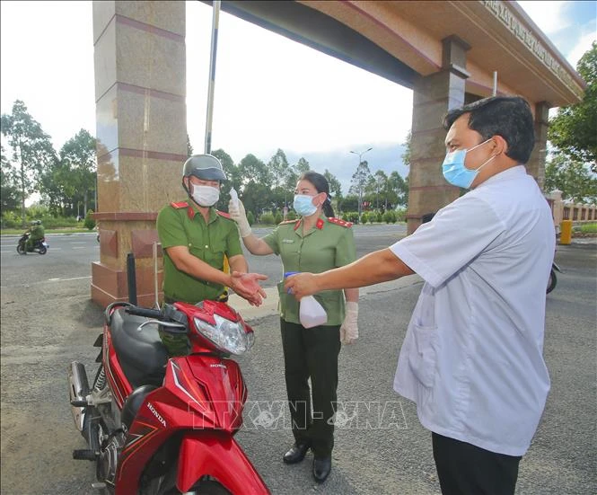 Đo thân nhiệt, rửa tay sát khuẩn phòng chống COVID - 19 tại điểm bỏ phiếu thuộc khu vực bầu cử số 3, phường V, thành phố Vị Thanh, sáng 21/5. Ảnh: Duy Khương - TTXVN