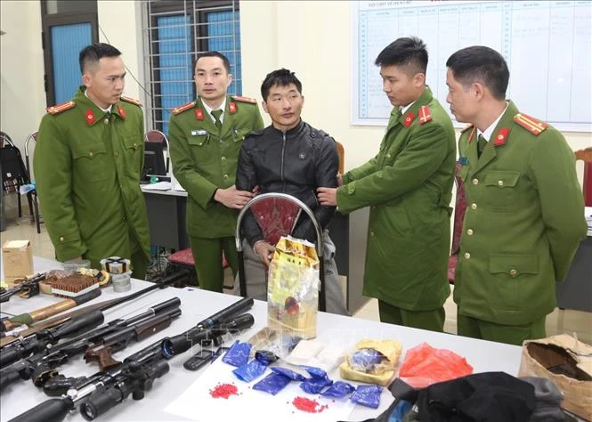 Đối tượng cùng tang vật tại cơ quan công an. Ảnh: TTXVN phát
