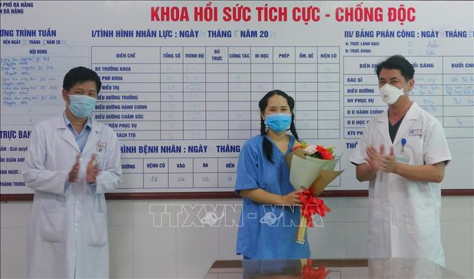 Lãnh đạo Bệnh viện Đà Nẵng trao hoa chúc mừng bệnh nhân. Ảnh: TTXVN