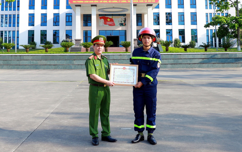 Đại tá Đỗ Tiến Thuỳ, Phó Giám đốc Công an tỉnh Tuyên Quang trao Bằng khen của Chủ tịch UBND tỉnh cho chiến sỹ Quan Ngọc Hoàng. Ảnh: Quang Cường- TTXVN 