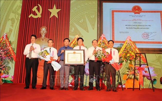 Thừa ủy quyền của Thủ tướng Chính Phủ, ông Nguyễn Văn Hùng, UVTW Đảng, Bí thư Tỉnh ủy Quảng Trị (thứ 2 từ phải sang) trao bằng công nhận huyện đạt chuẩn nông thôn mới cho huyện Cam Lộ. Ảnh: Hồ Cầu/TTXVN