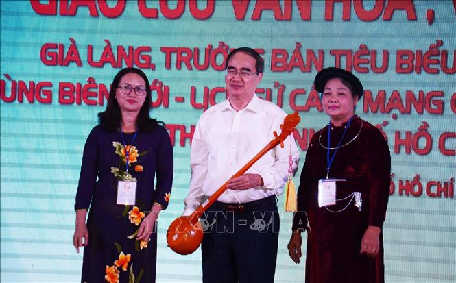 Bí thư Thành ủy Thành phố Hồ Chí Minh Nguyễn Thiện Nhân nhận chiếc đàn tính là quà tặng của Đoàn đại biểu các già làng, trưởng bản dân tộc tiêu biểu các tỉnh biên giới-lịch sử cách mạng phía Bắc. Ảnh: Xuân Khu-TTXVN