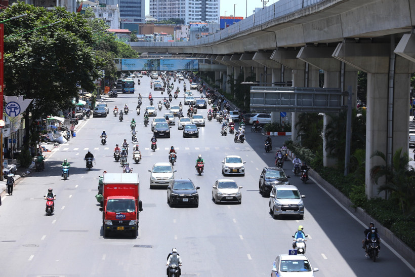 Người dân mặc kín mít khi phải di chuyển trên đường giữa trời nắng nóng. Ảnh: Hoàng Hiếu - TTXVN 