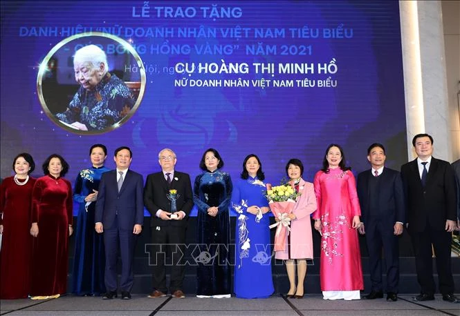 Phó Chủ tịch nước Võ Thị Ánh Xuân và Trưởng Ban Dân vận Trung ương Bùi Thị Minh Hoài trao Cúp và hoa cho đại diện gia đình cụ Hoàng Thị Minh Hồ. Ảnh: Trọng Đức - TTXVN 