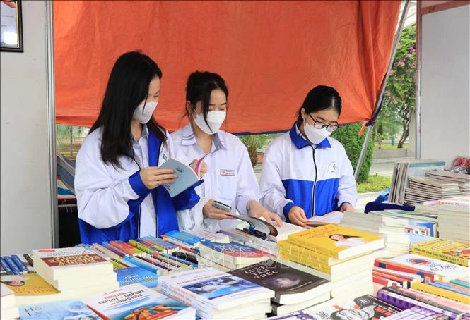Các em học sinh đọc sách tại Ngày sách. Ảnh: Thái Hùng - TTXVN 