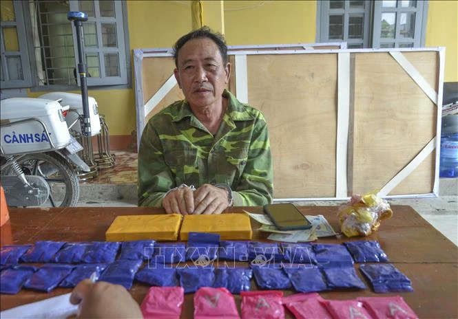 Đối tượng Tòng Văn Hoa cùng tang vật. Ảnh: TTXVN phát 