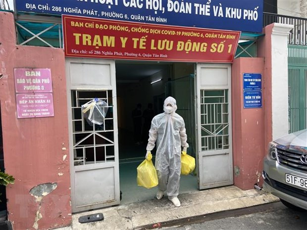 Lực lượng Quân y tại Trạm y tế lưu động số 1 (Phường 6, quận Tân Bình) mang các đồ dùng cần thiết (bình oxy, máy đo nồng độ oxy, ống nghe, nhiệt kế, dung dịch sát khuẩn, khẩu trang…) để đến nhà F0. Ảnh: Mạnh Linh - TTXVN) 