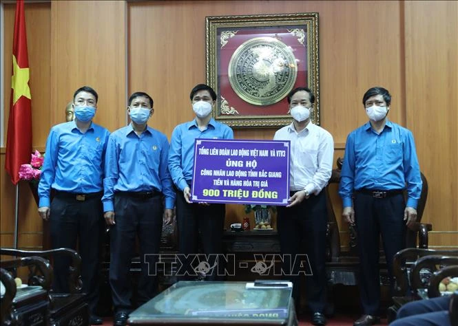 Phó Chủ tịch Tổng Liên đoàn Lao động Việt Nam Ngọ Duy Hiểu tặng quà cho đại diện tỉnh Bắc Giang. Ảnh: Danh Lam- TTXVN 