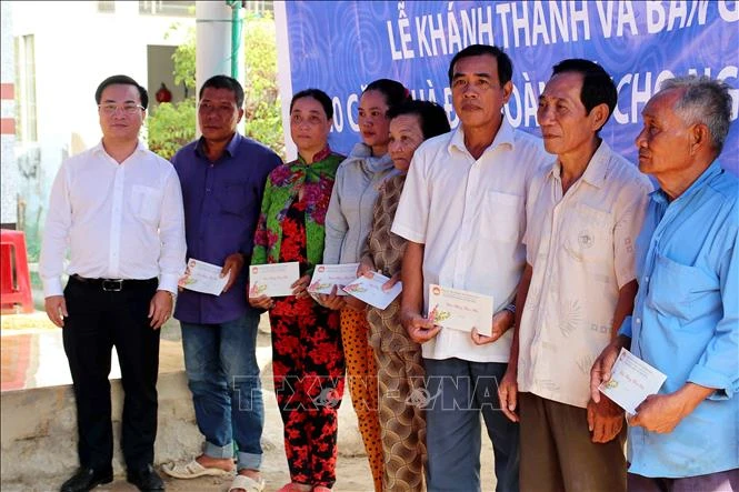 Đại diện BIDV Cà Mau trao quà cho các hộ thuộc diện nghèo tại xã Tân Hưng Đông, huyện Cái Nước tại buổi lễ. Ảnh: Kim Há-TTXVN