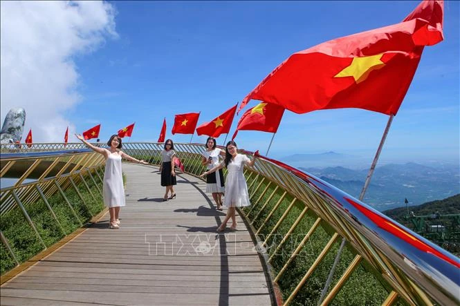 Đà Nẵng: Cầu Vàng rực rỡ cờ Tổ quốc đón du khách sau dịch COVID-19. Ảnh: Trần Lê Lâm - TTXVN
