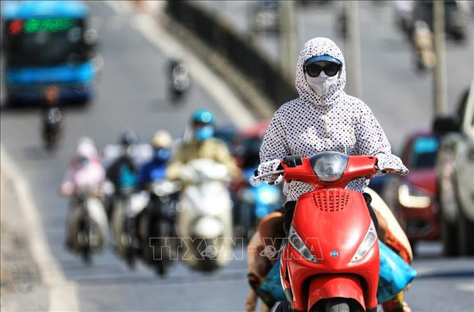 Nhiệt độ trên 35 độ C là từ 12-17 giờ, người tham gia giao thông cần trang bị khẩu trang, áo chống nắng che kín người tránh tình trạng sốc nhiệt vì nắng nóng. Ảnh: Thành Đạt - TTXVN
