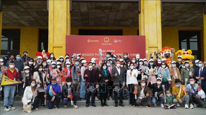 Các hành khách chụp ảnh lưu niệm với lãnh đạo tỉnh Quảng Ninh. Ảnh: TTXVN phát 