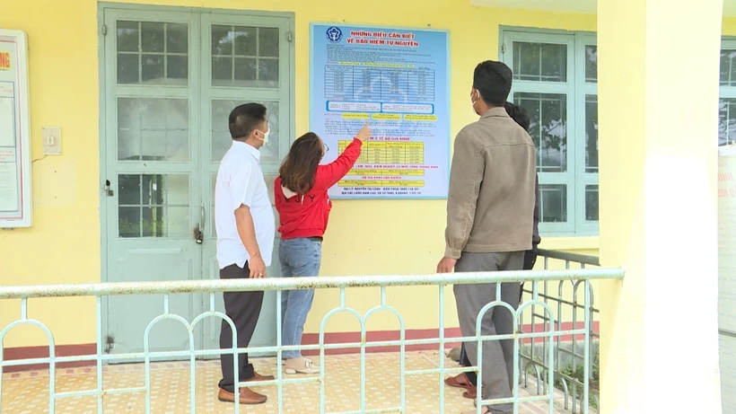 Cán bộ đại lý thu, mua BHYT tư vấn các mức hỗ trợ đóng BHYT cho người dân. Ảnh: Hoài Nam - TTXVN 