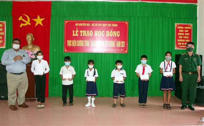 Lãnh đạo Hội Khuyến học và Bộ đội Biên phòng tỉnh Sóc Trăng trao học bổng cho học sinh vùng biên giới biển. Ảnh: Trung Hiếu - TTXVN 