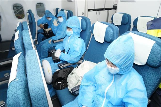 Chuyến bay thương mại quốc tế đầu tiên của hàng không Việt Nam sau dịch COVID-19, hành khách trên chuyến bay được sắp xếp ngồi giãn cách. Ảnh: Huy Hùng - TTXVN