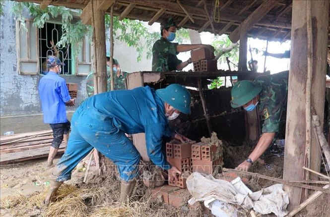 Bộ đội giúp gia đình bà Phạm Thị Quờn xã Sơn Hà, huyện Sơn Hòa, tỉnh Phú Yên dọn dẹp nhà sau lũ. Ảnh: Xuân Triệu – TTXVN 