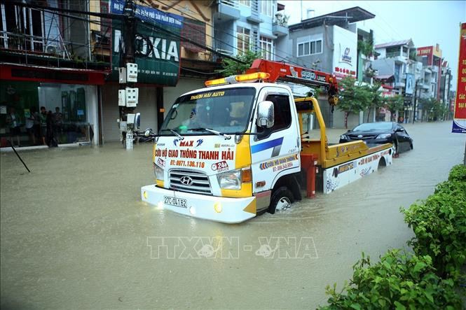 Xe cứu hộ giao thông kéo một phương tiện bị chết máy do ngập nước. Ảnh: Phan Tuấn Anh - TTXVN