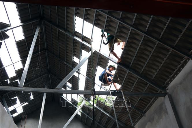 Người dân bản Tháng Năm, xã Tà Lại, huyện Mộc Châu lợp lái mái nhà bị hư hỏng do động đất. Ảnh: Hữu Quyết - TTXVN