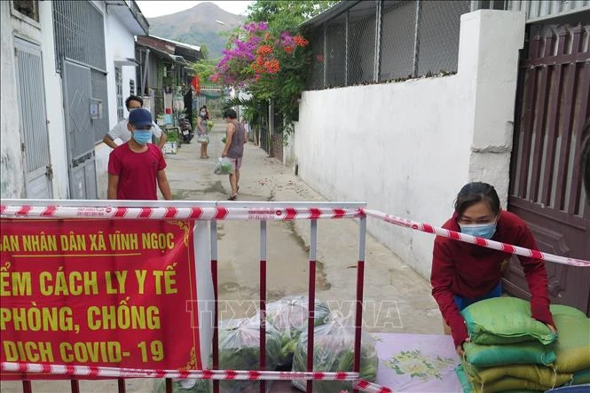 Người dân ở khu cách ly y tế ở xã Vĩnh Ngọc, thành phố Nha Trang nhận hỗ trợ gạo và nhu yếu phẩm. Ảnh: Phan Sáu - TTXVN