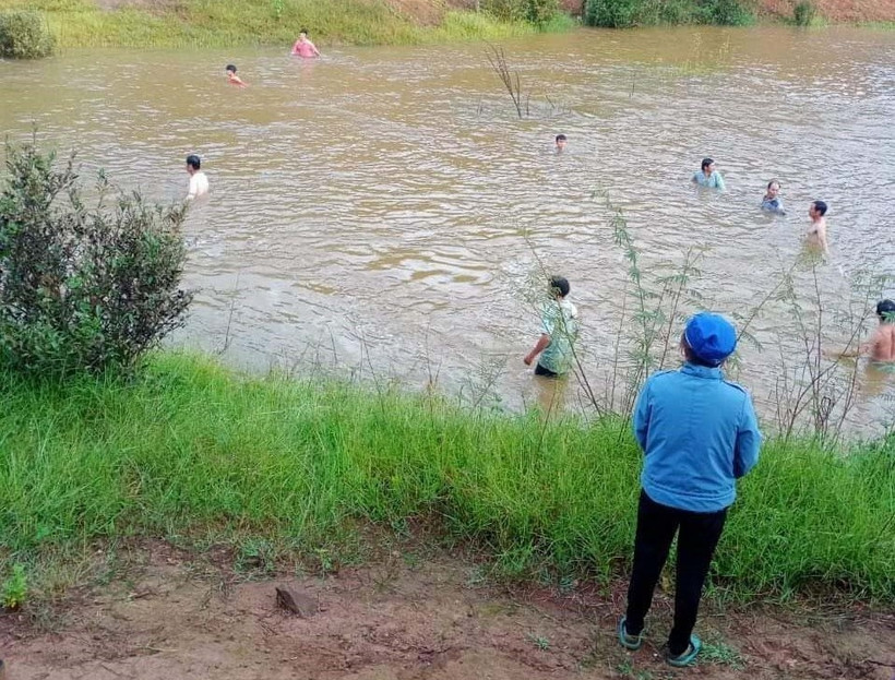 Lực lượng chức năng hỗ trợ gia đình tìm kiếm, vớt thi thế cháu L.P.B.M bị đuối nước. Ảnh: TTXVN phát 