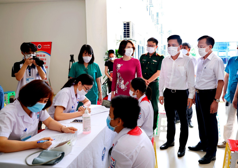 Thứ trưởng Bộ Y tế Nguyễn Thị Liên Hương, Phó Chủ tịch UBND tỉnh Vĩnh Phúc Vũ Việt Văn kiểm tra công tác tư vấn, khám sàng lọc cho các em học sinh trước khi tiêm vaccine phòng COVID-19. Ảnh: Nguyễn Thảo – TTXVN 