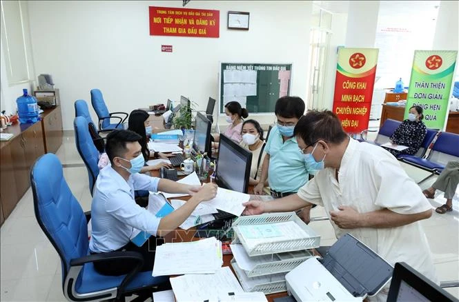 Hướng dẫn người dân khai hồ sơ tại Trung tâm Phục vụ hành chính công tỉnh Lạng Sơn. Ảnh: Anh Tuấn - TTXVN 