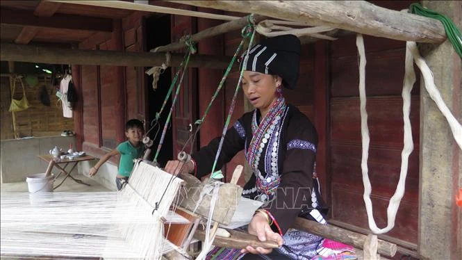 Người phụ nữ Lự tận dung thời gian rảnh rỗi để dệt những bộ quần áo cho gia đình. Ảnh: Việt Hoàng-TTXVN