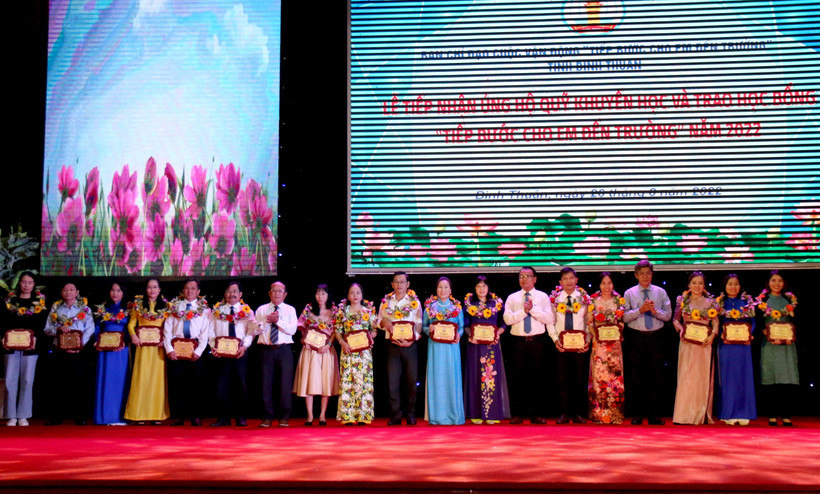 Tặng biểu trưng và hoa cho các đơn vị ủng hộ cho Quỹ học bổng “Tiếp bước cho em đến trường”. Ảnh: Nguyễn Thanh – TTXVN 