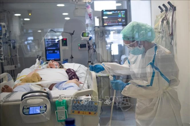 Nhân viên y tế điều trị cho bệnh nhân COVID-19 tại Barcelona, Tây Ban Nha. Ảnh: AFP/ TTXVN 