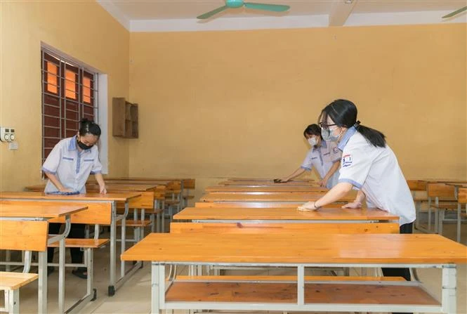 Lau dọn vệ sinh đảm bảo khu vực phòng thi luôn được sạch sẽ. Ảnh: Bích Huệ - TTXVN 