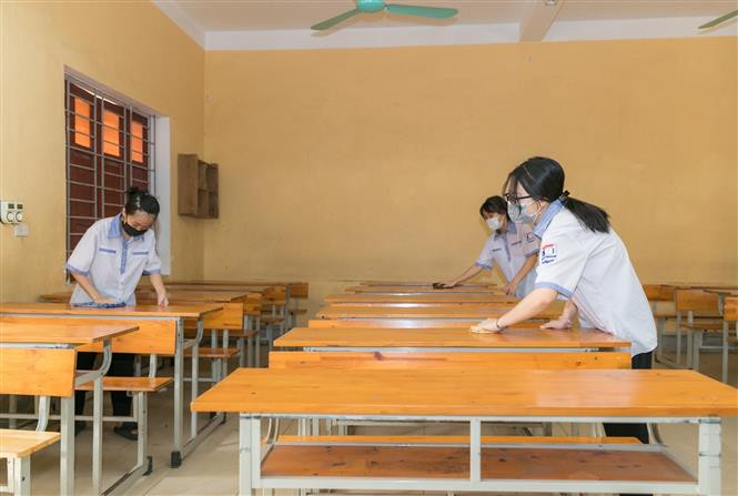 Lau dọn vệ sinh đảm bảo khu vực phòng thi luôn được sạch sẽ. Ảnh: Bích Huệ - TTXVN 