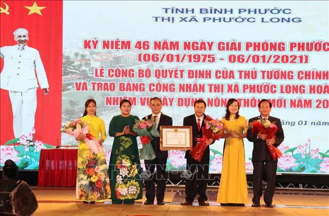 Lãnh đạo tỉnh Bình Phước thừa Ủy quyền trao quyết định của Thủ tướng công nhận thị xã Phước Long hoàn thành nhiệm vụ xây dựng nông thôn mới. Ảnh: Sỹ Tuyên -
