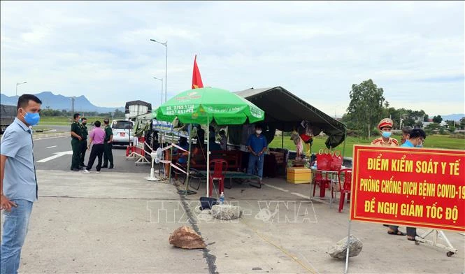 Kiểm tra thân nhiệt người qua lại vùng dịch Quảng Nam. Ảnh: Trần Tĩnh - TTXVN