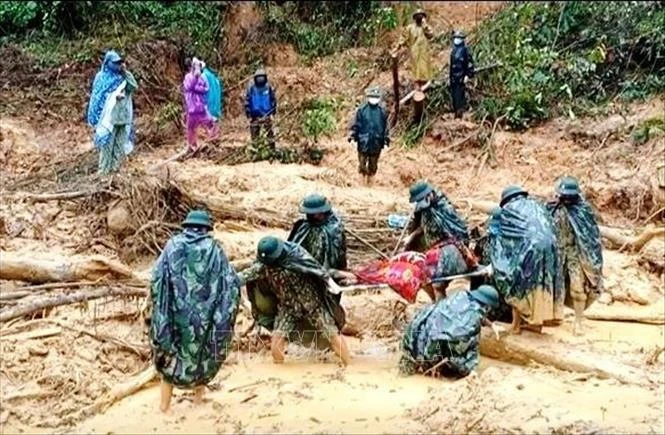 Thi thể các nạn nhân được tìm thấy tại hiện trường vụ sạt lở đất. Ảnh: TTXVN phát