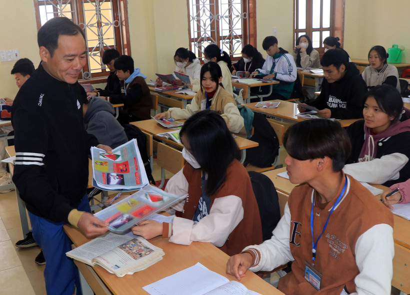 Cán bộ Trung tâm Y tế phát tờ rơi tuyên truyền về sức khỏe sinh sản cho học sinh. Ảnh: Hữu Quyết – TTXVN 