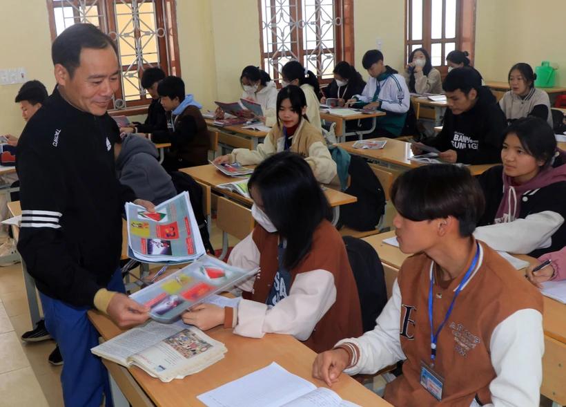 Cán bộ Trung tâm Y tế phát tờ rơi tuyên truyền về sức khỏe sinh sản cho học sinh. Ảnh: Hữu Quyết – TTXVN 