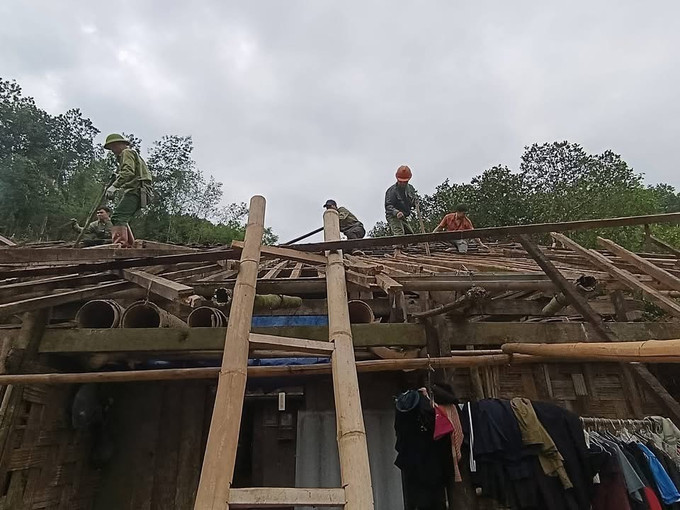 Lực lượng chức năng hỗ trợ người dân sửa chữa căn nhà bị tốc mái do dông lốc, mưa đá. Ảnh: TTXVN phát