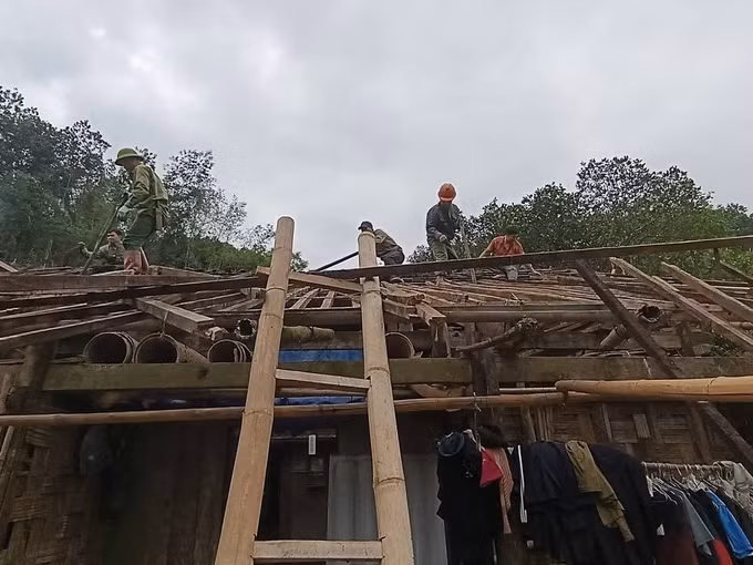 Lực lượng chức năng hỗ trợ người dân sửa chữa căn nhà bị tốc mái do dông lốc, mưa đá. Ảnh: TTXVN phát