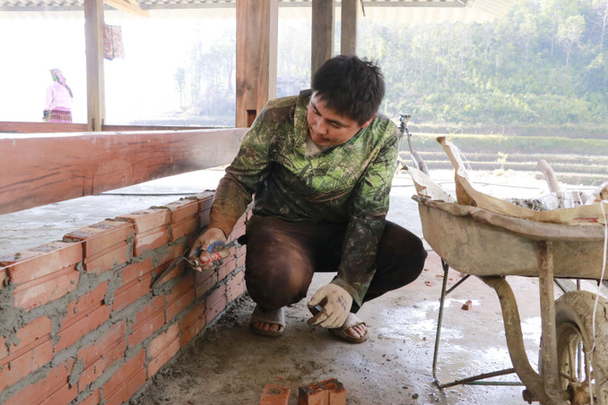 Anh Thào Thành Sinh, thôn Làng Sang, xã Púng Luông phấn khởi cố gắng hoàn thiện ngôi nhà trước ngày 25/12 âm lịch để vợ con sắm Tết.