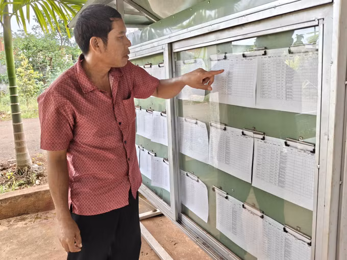 Trưởng thôn Điểu Xu xem thông tin danh sách cử tri tại nhà văn hóa thôn Bình Lợi.