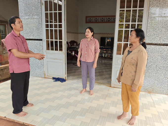 Trưởng thôn Điểu Xu (trái) đến từng nhà tuyên truyền cho người dân về bầu cử.