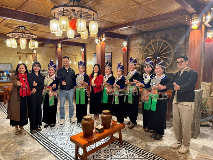 Du khách thưởng thức rượu cần với đồng bào dân tộc Mông. Ảnh: TTXVN phát