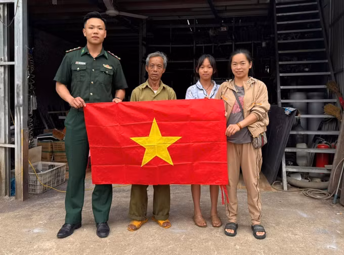 Trung úy Hoàng Trung Kiên tặng cờ Tổ quốc cho đồng bào khu vực biên giới.